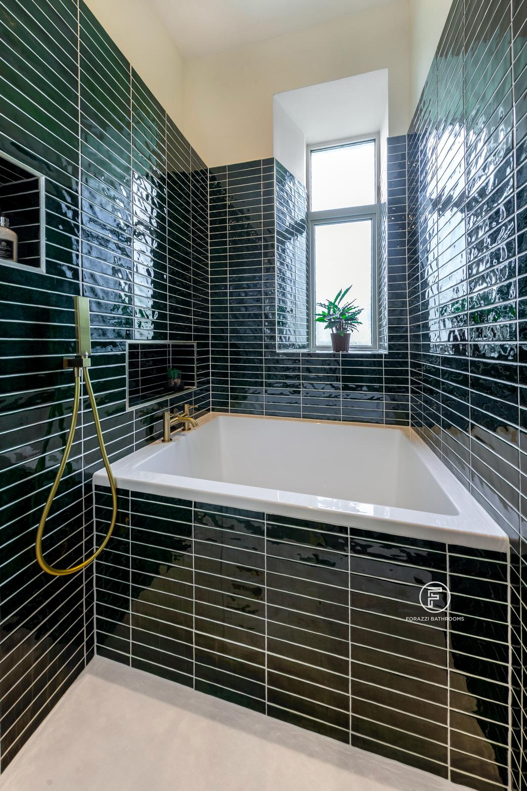 Compact Edinburgh tenement bathroom by Forazzi Bathrooms — 1300 × 950mm Omnitub Solo Sups deep soaking tub in glazed emerald tile alcove with brushed brass shower handheld and original tenement window — handmade in Britain