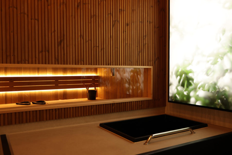 Slatted cedar, backlit bench niche, bucket and stones