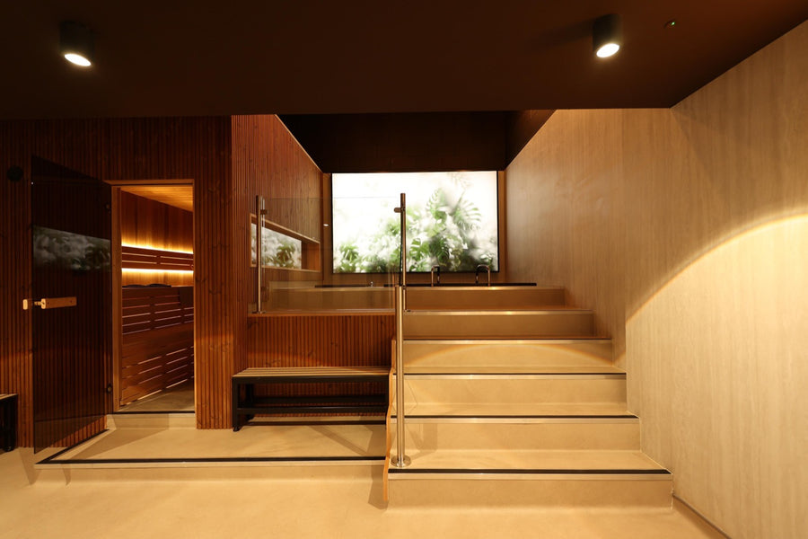 The full room — sauna, bench, stepped deck to the tubs
