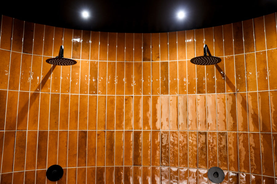 Black plunge tub in the burnt-orange tiled experience room