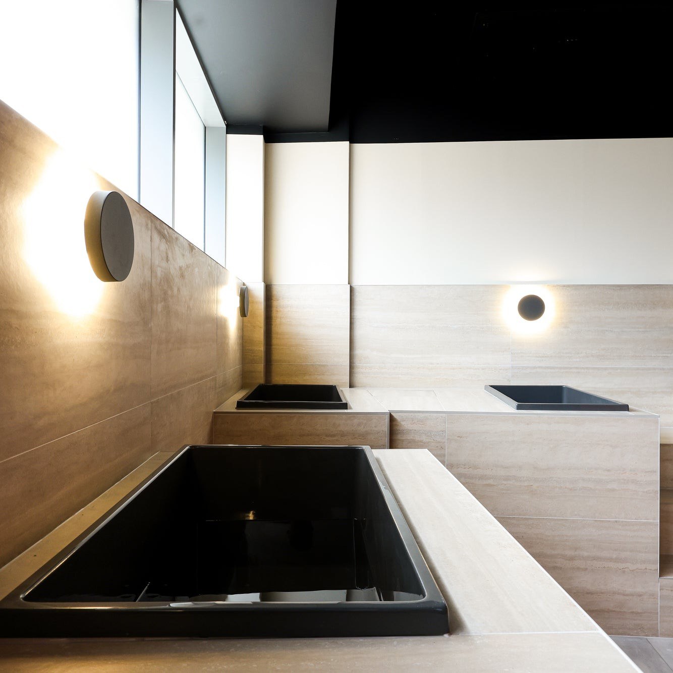 Black plunge ice baths in a premium spa install — Omnitub