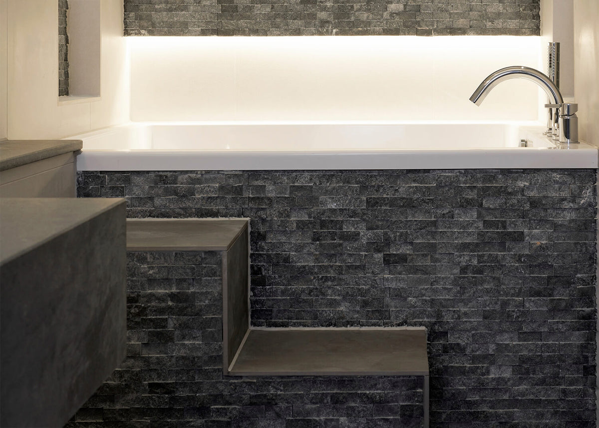 Deep white Omnitub set into dark slate with bespoke steps